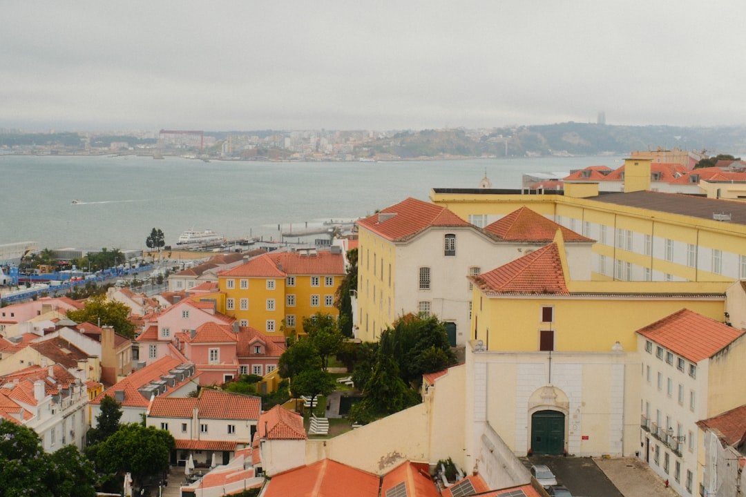 Colorful tiled buildings in Lisbon's Alfama district with tram 28 passing through narrow streets