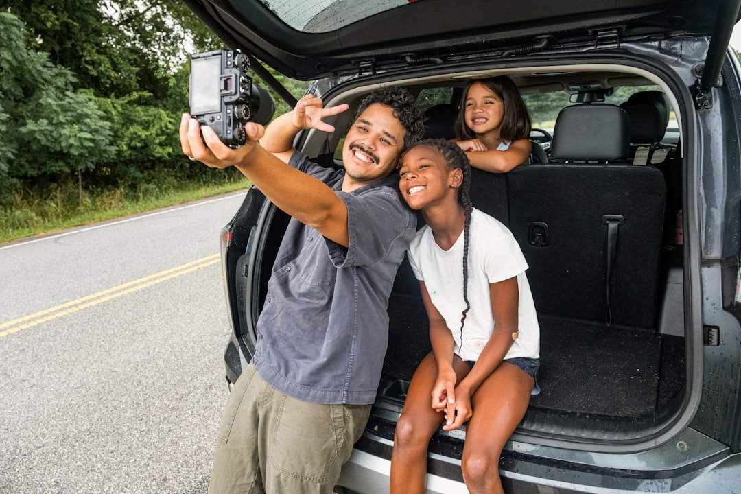 Happy family with children laughing together in car during road trip