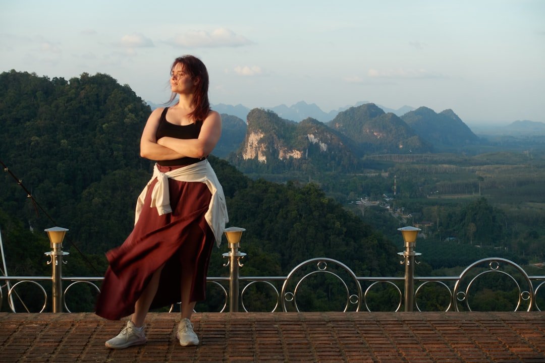 Confident woman traveler checking a map while standing at a scenic overlook during golden hour